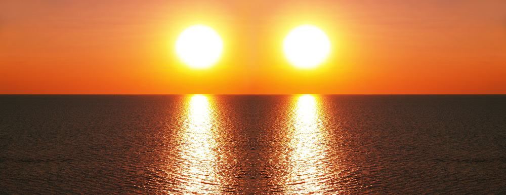 Imagem mostra duas estrelas iluminando uma paisagem de mar, simbolizando um estudo que afirma que o Sol tem uma estrela irmã gêmea