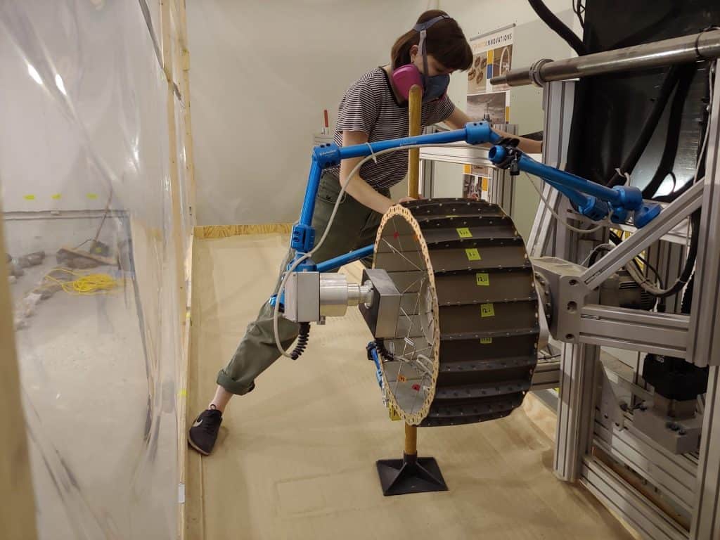 Pesquisadora realizando testes na roda de metal da Nasa