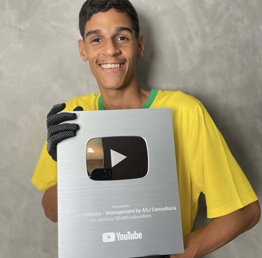 Luva de Pedreiro segurando sua placa de 100 mil inscritos