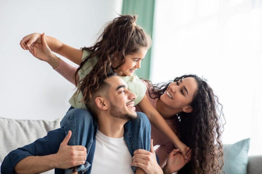 Família feliz se abraça enquanto sorri