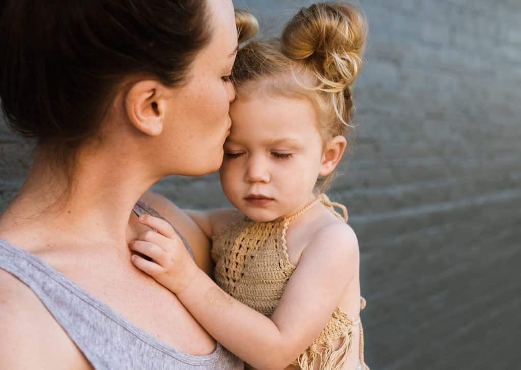Uma mãe beijando sua filhinha