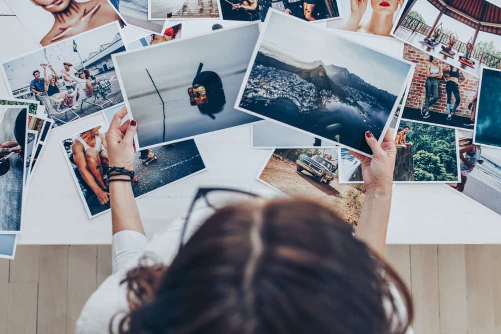 Mulher analisando fotos em cima de uma mesa