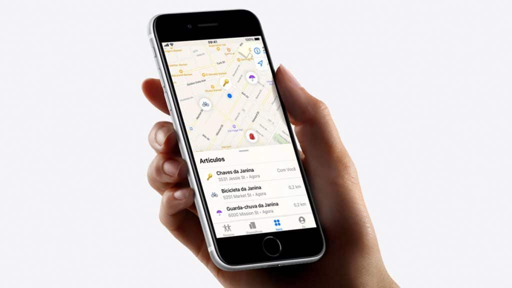 Pessoa segurando iPhone com app Buscar aberto e rastreando objetos com AirTag