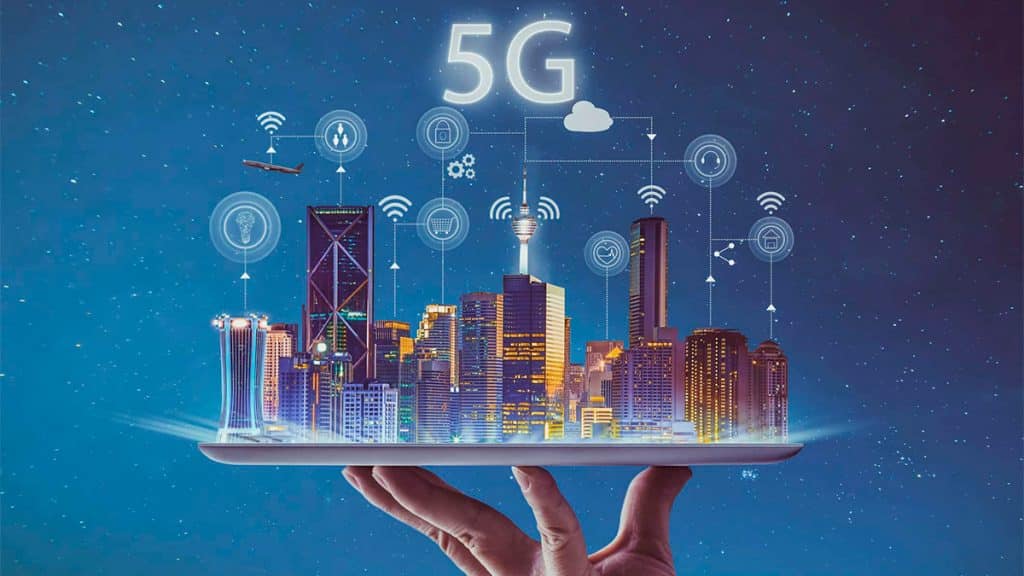 Pessoa segurando tablet projetando cidade com ilustrações das aplicações do 5G