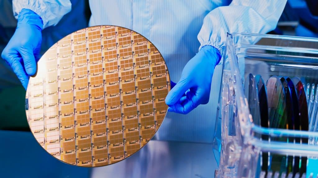 Técnico segura wafer com luvas em fábrica de chips