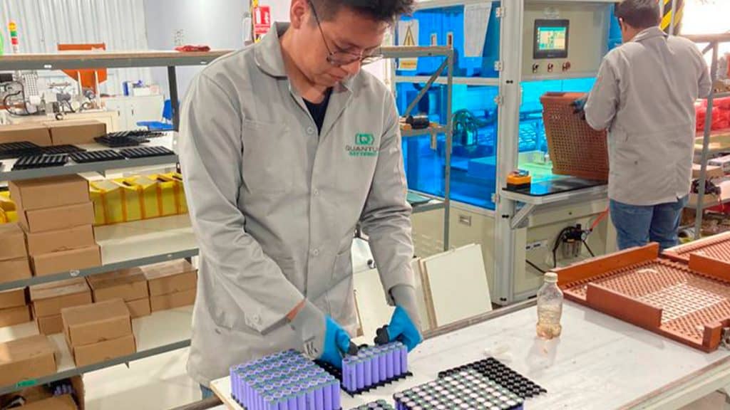 Funcionário da Quantum mexendo com baterias de lítio em linha de montagem