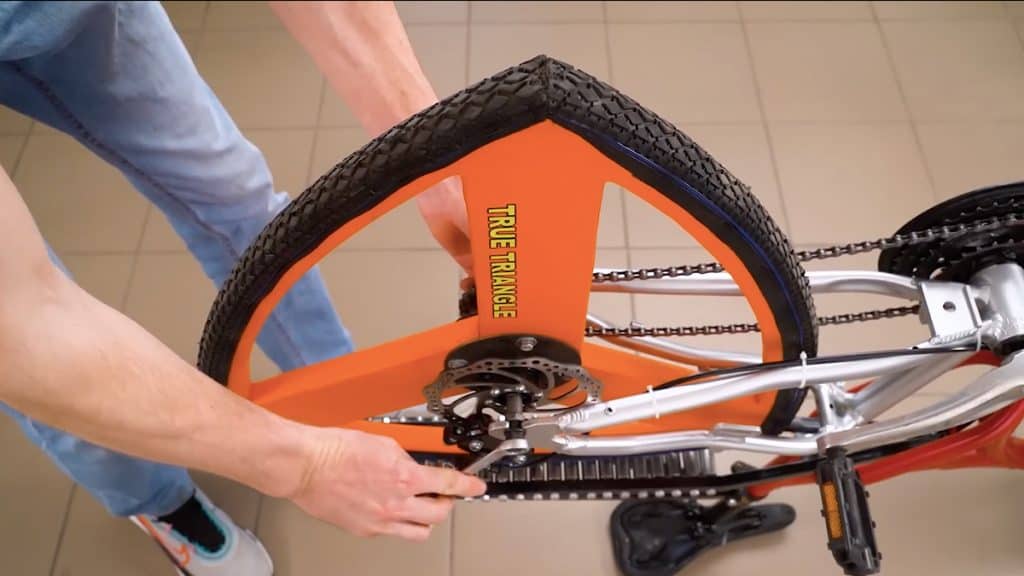 Homem fazendo bicicleta com roda triangular