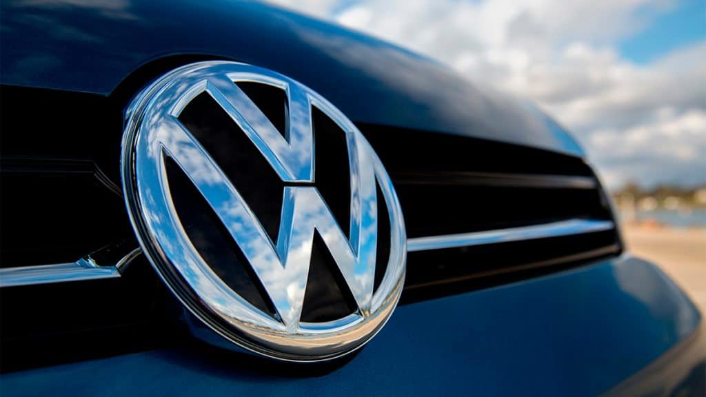 Close em insígnia da Volkswagen num dos carros da marca