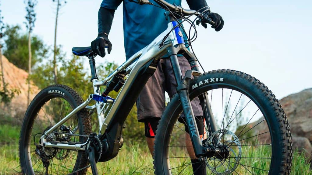 Homem empurrando nova bicicleta elétrica da Yamaha em trilha