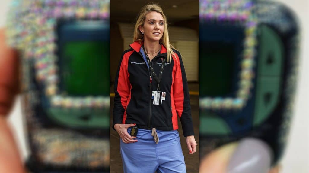 Médica vestida com uniforme de hospital com pager pendurado na cintura