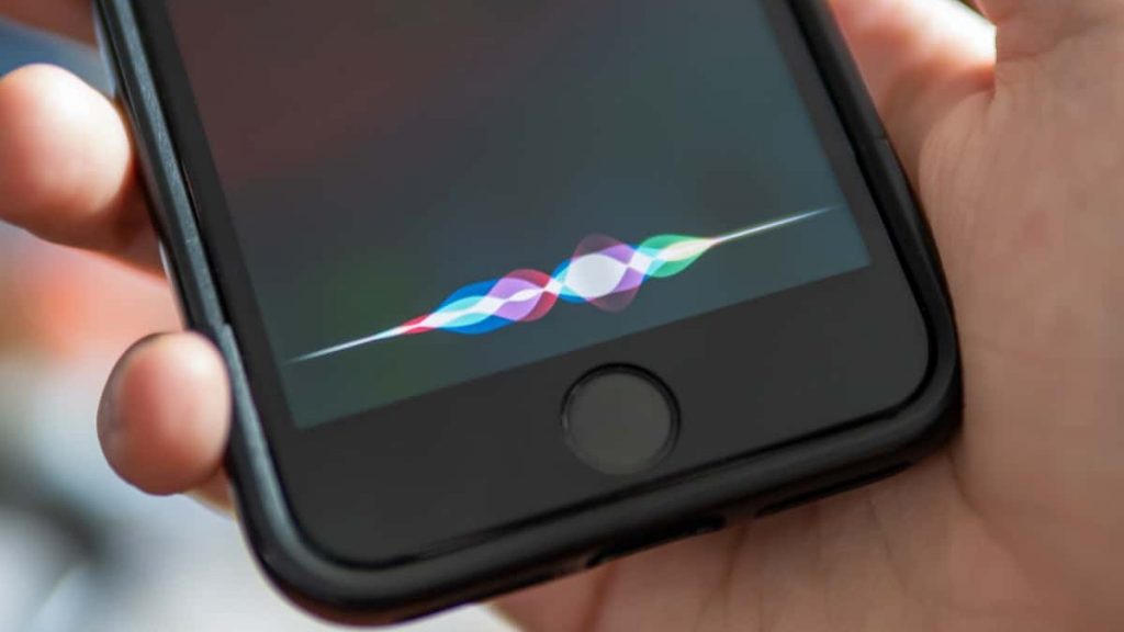 Pessoa segurando iPhone enquanto ativa a Siri