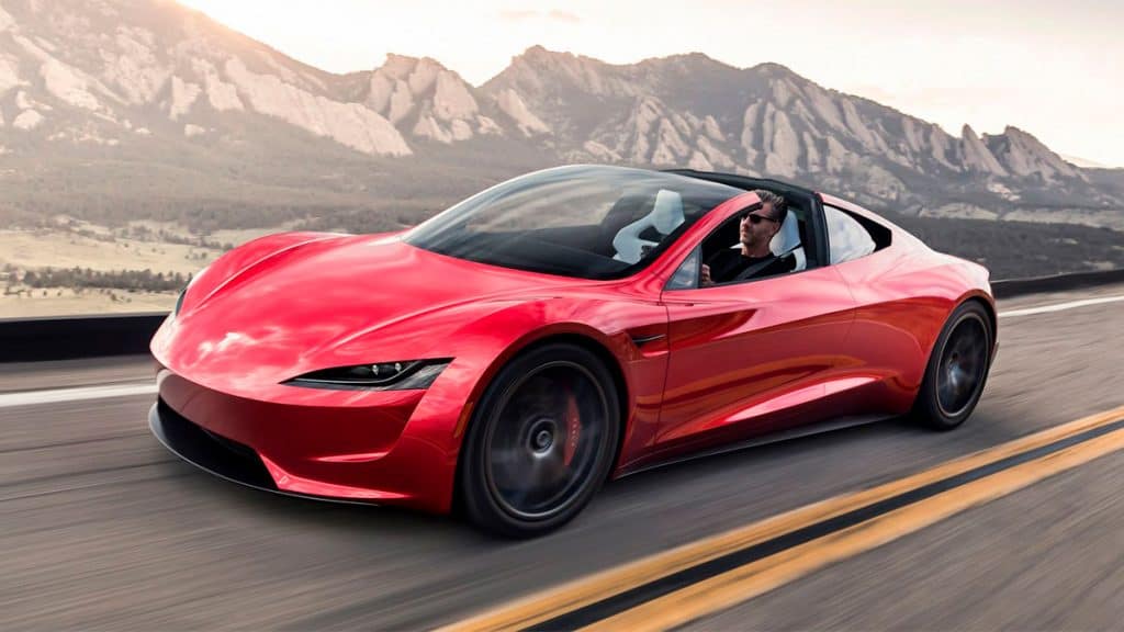 Homem dirigindo Tesla Roaster conversível na rodovia