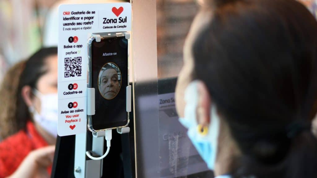 Mulher usando tecnologia para pagar com o rosto em loja