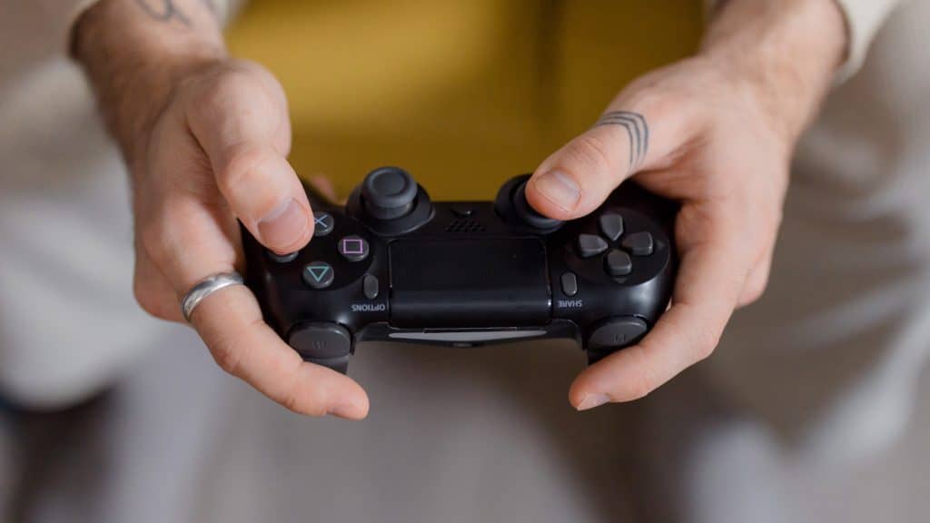 Homem segurando controle do PS4