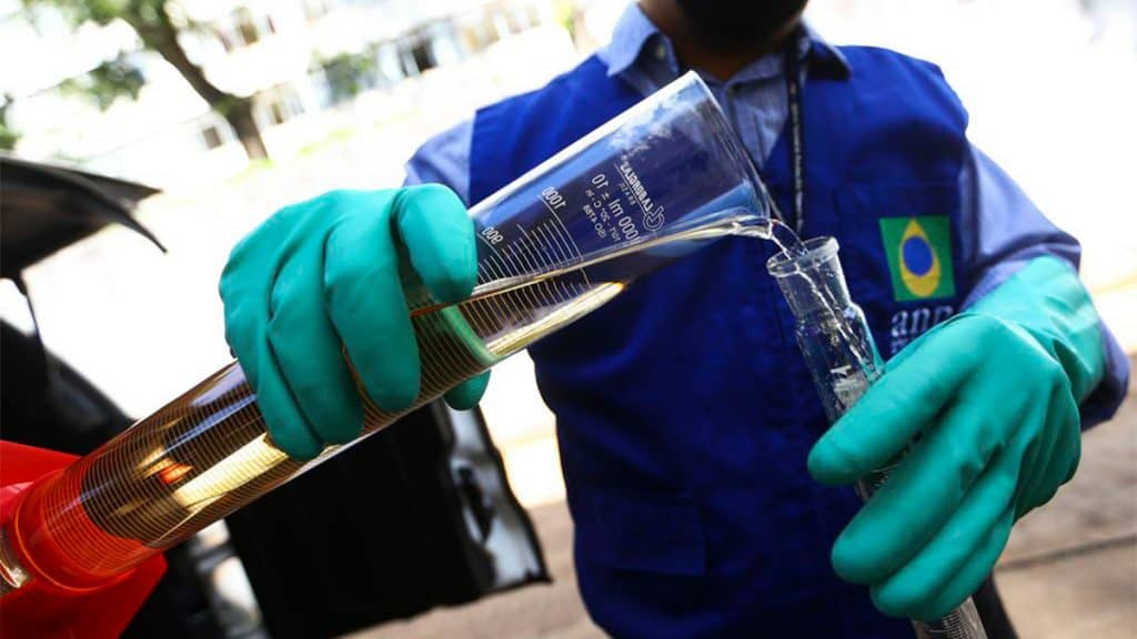 Homem colocando etanol em vidro de laboratório