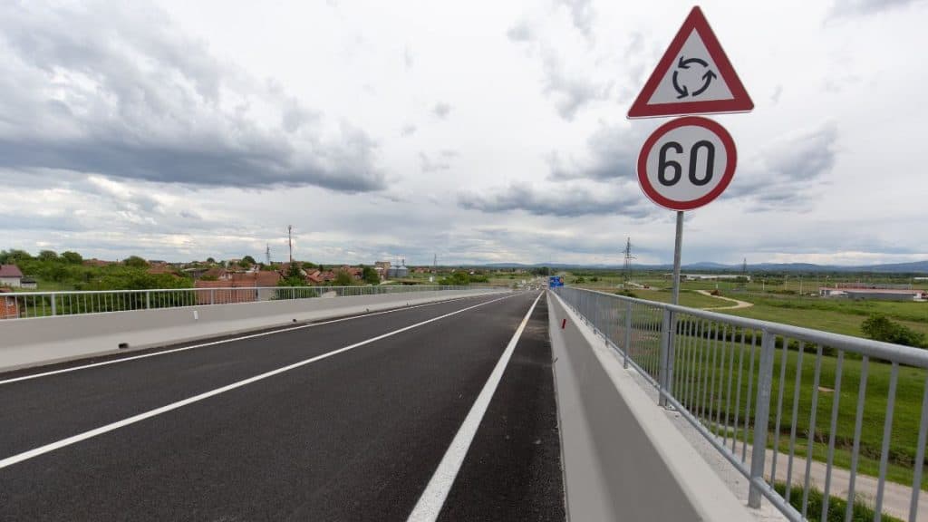 Placa de sinal de rotatória e outra de velocidade 60