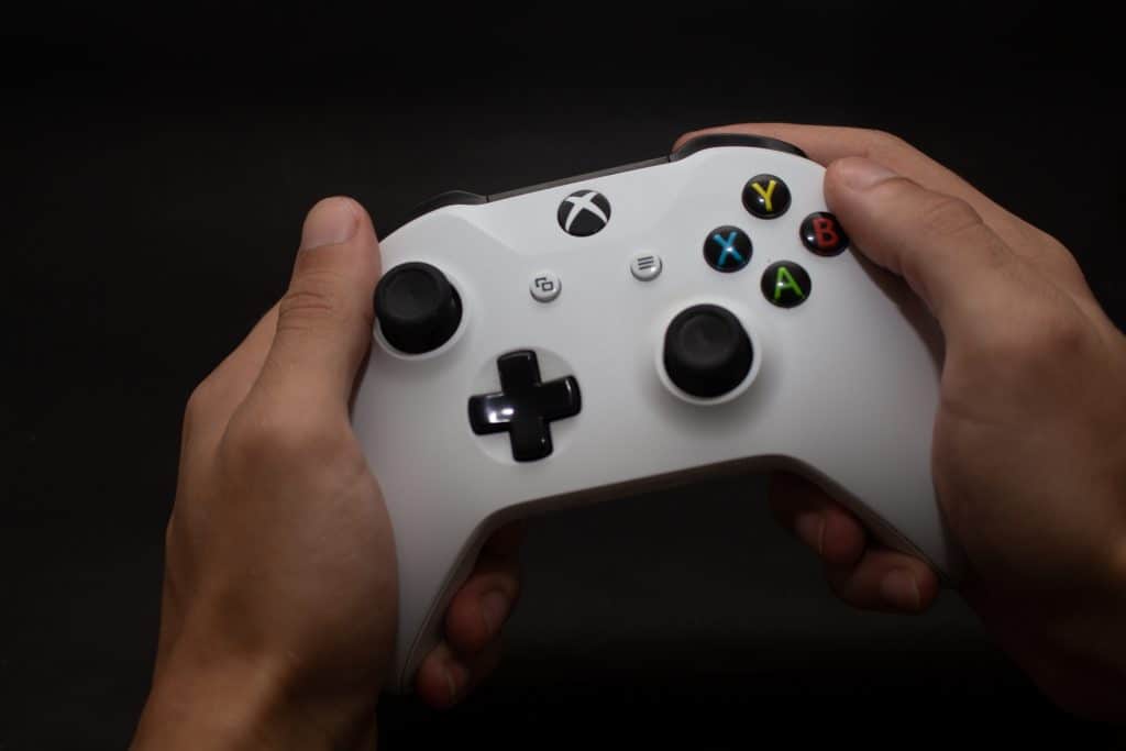 Mãos segurando o controle do Xbox One S da Microsoft