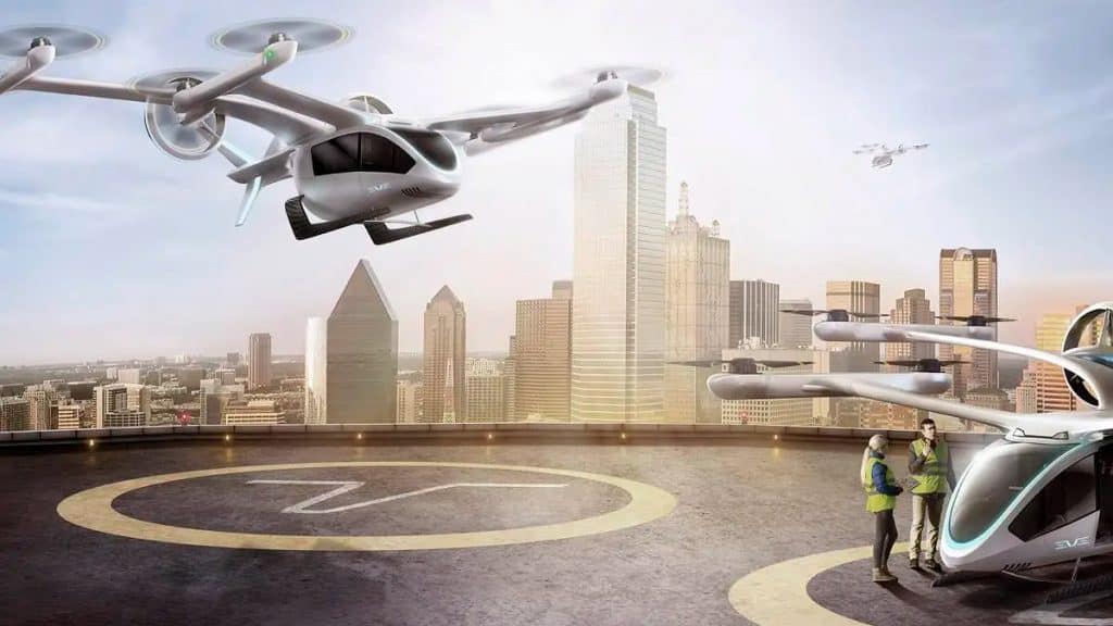 Imagem ilustrativa mostra carro voador da Embraer pousando em um vertiporto instalado em ambiente urbano.