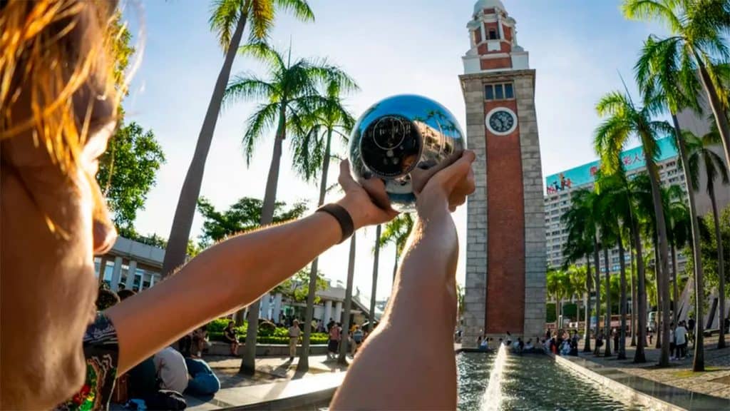 Pessoa segurando orbe da Worldcoin enquanto tem seus olhos escaneados