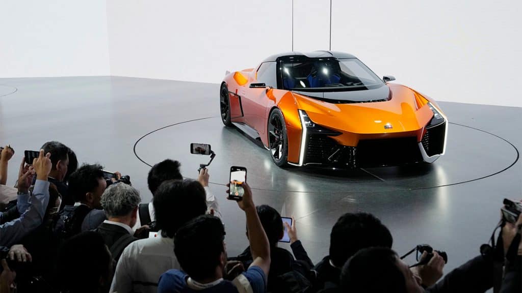 Pessoas tirando foto e gravando vídeo de carro elétrico exibido no Salão do Automóvel de Tóquio em 2023