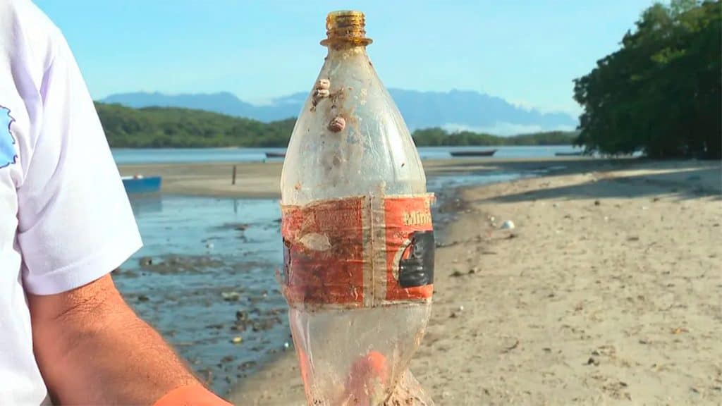 Homem segurando garrafa de Coca-Cola comemorativa da Copa de 1998