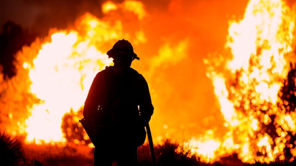Silhueta de bombeiro encarando incêndio na Califórnia