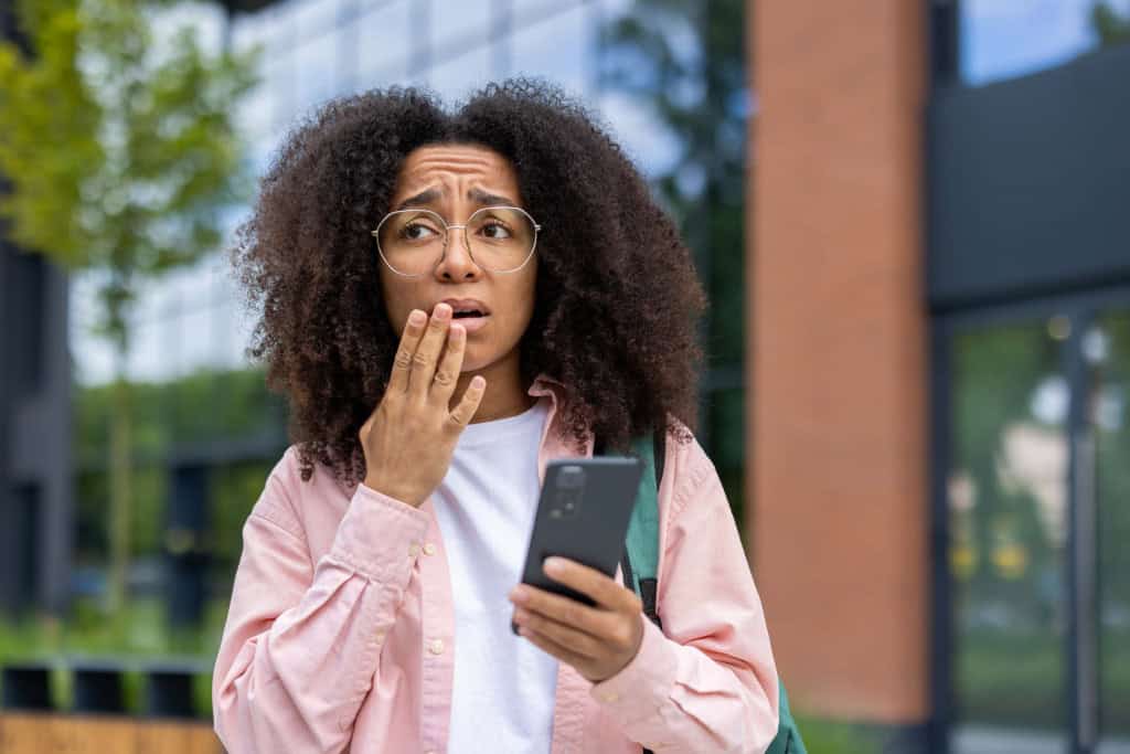 Mulher preocupada com o celular na mão