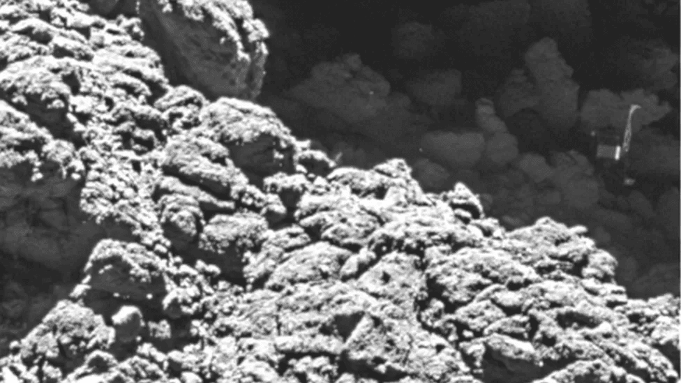 [ Philae, no canto direito da imagem, após quicar no cometa e parar, tombada, em uma região com baixa iluminação solar - Créditos: ESA/Rosetta/MPS ]