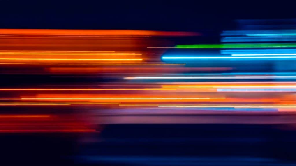 Ilustração com rastros coloridos de luz na horizontal