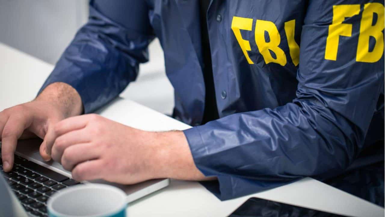 Agente do FBI mexendo em um computador