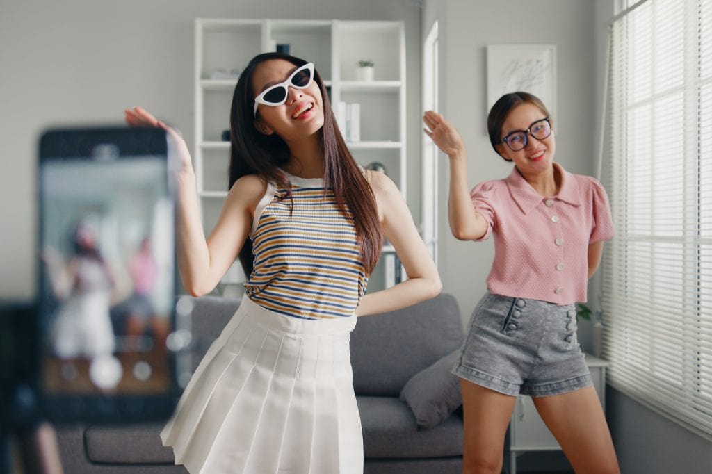 Duas meninas dançando em frente a um smartphone, que as grava