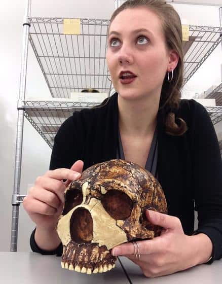 Foto mostra a paleontóloga Kimberly Foecke segurando o crânio de um Neandertal