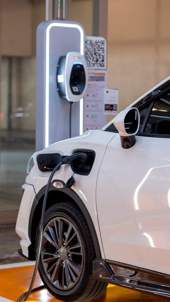 Carro elétrico plugado a estação de carregamento