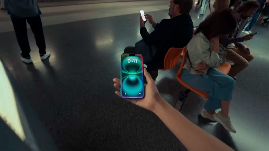 Pessoa segurando iPhone 16 com Apple Intelligence ativada numa estação de metrô