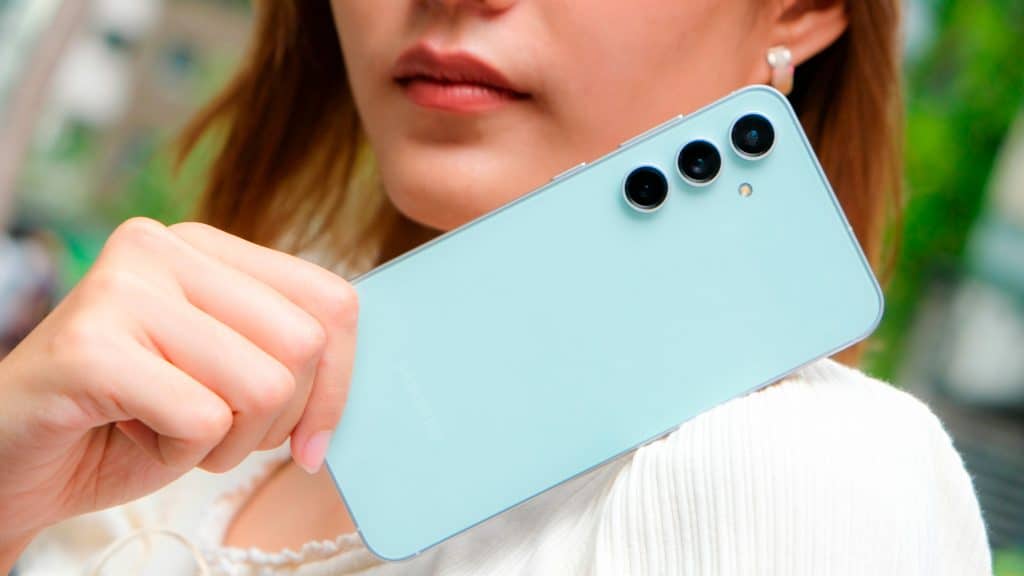 Mulher segurando celular Samsung Galaxy S23 FE ao lado do rosto