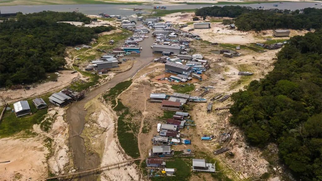 Visão aérea de rio seco na Amazônia, com galpões na sua margem