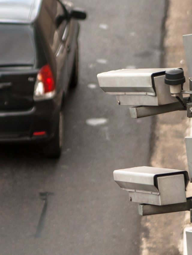 Três radares de trânsito apontando para carro na rua