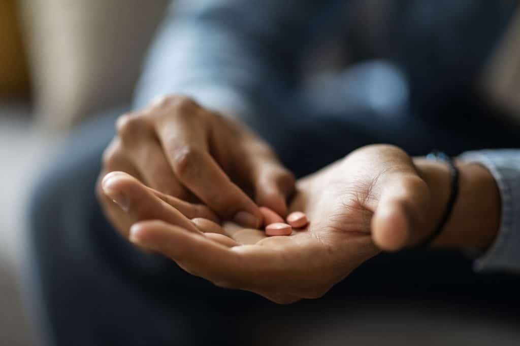 homem com medicamentos na mão