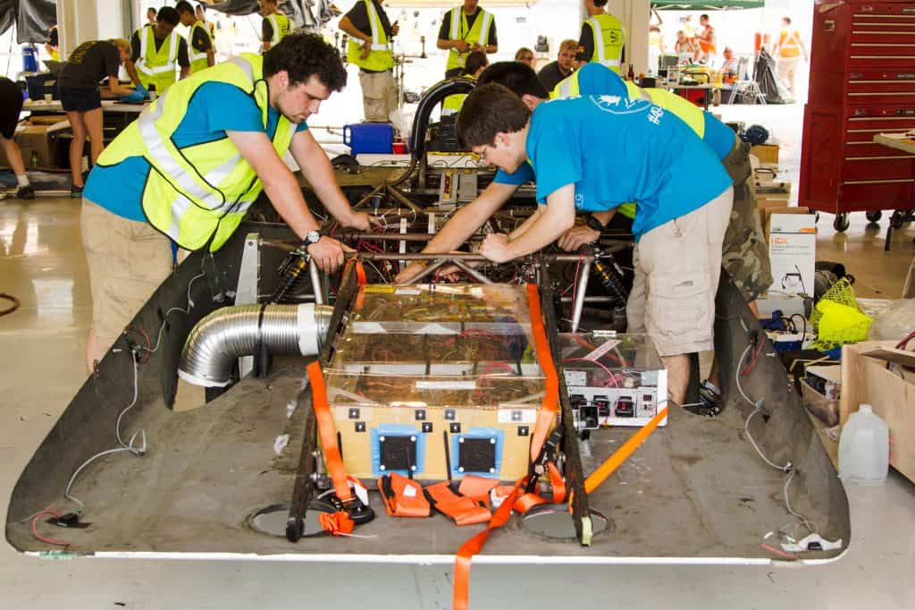 pessoas em torno de um carro solar
