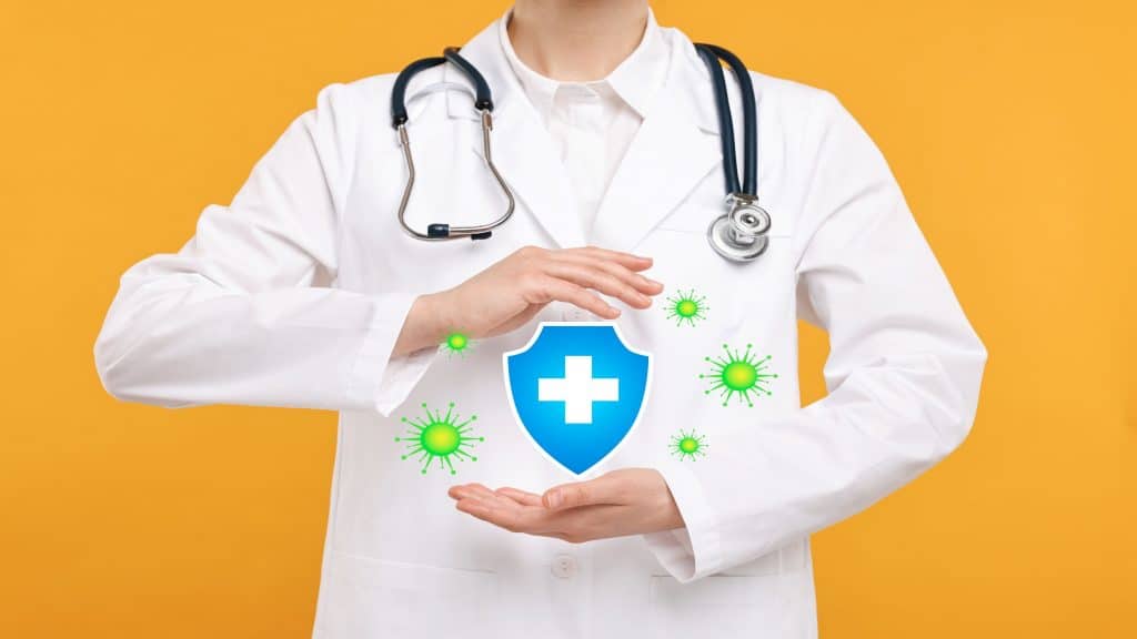 Imunidade forte bloqueando vírus. Médico segurando ilustração de escudo em fundo laranja, close-up.