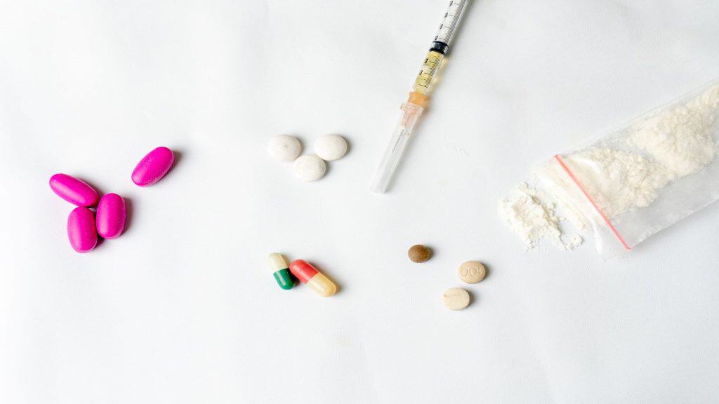 O que é a cocaína rosa? Entenda os riscos que ela representa à saúde Nos últimos anos, emergiu no mercado de drogas uma substância apelidada de cocaína rosa (também chamada de pink cocaine, tusi, tucibi, tuci, entre outros). O nome sugere uma variação da cocaína tradicional, mas na prática raramente contém cocaína pura. Trata-se de uma mistura imprevisível de substâncias psicoativas, muitas delas sintéticas. Substâncias narcóticas, pó de droga, seringa e pílulas brancas, pílulas rosas sobre um fundo texturizado branco. Conceito de vício e maus hábitos.