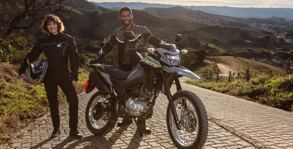 Homem com uma moto Honda NXR 160 Bros