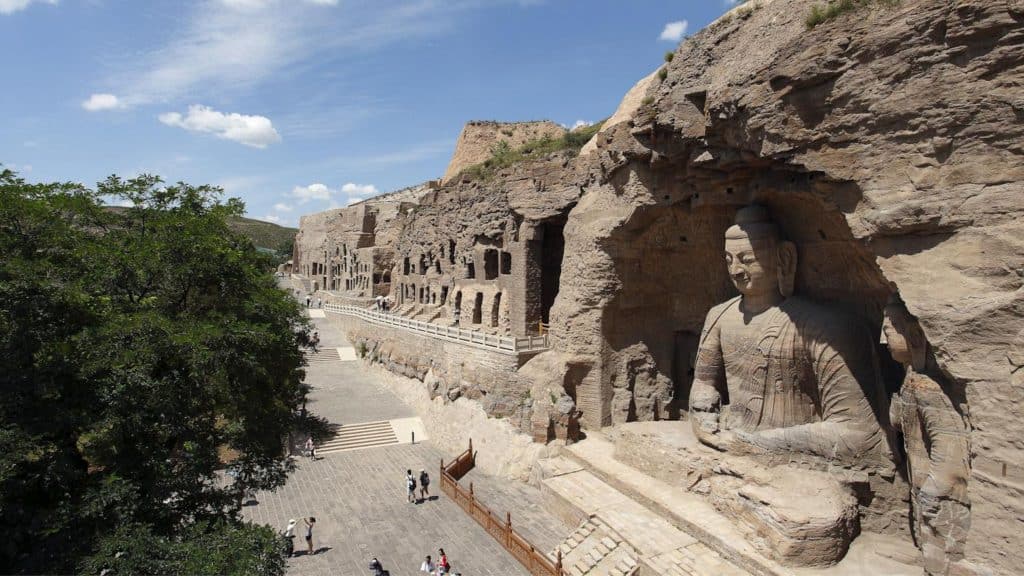 Estátua enorme esculpida em pedra na entrada da caverna de Yugang na China
