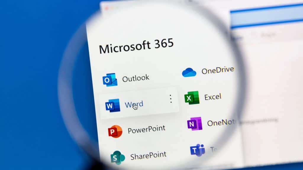 Claude ganha integração com Teams, Outlook e OneDrive A Anthropic anunciou uma nova integração entre seu assistente de inteligência artificial, Claude, e o Microsoft 365, ampliando as possibilidades de uso do chatbot em ambientes corporativos. A novidade permite que o Claude acesse conteúdos de Word, Outlook, Teams, OneDrive e SharePoint, oferecendo respostas mais completas e contextuais sem que o usuário precise enviar arquivos manualmente. As informações são do The Verge. Pessoa segurando lupa sobre página com programas do Microsoft 365 (antigo Office) listados