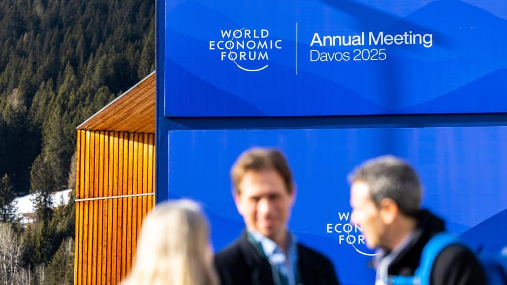 Três pessoas conversando na parte de fora do Fórum Econômico Mundial realizado em Davos em 2025