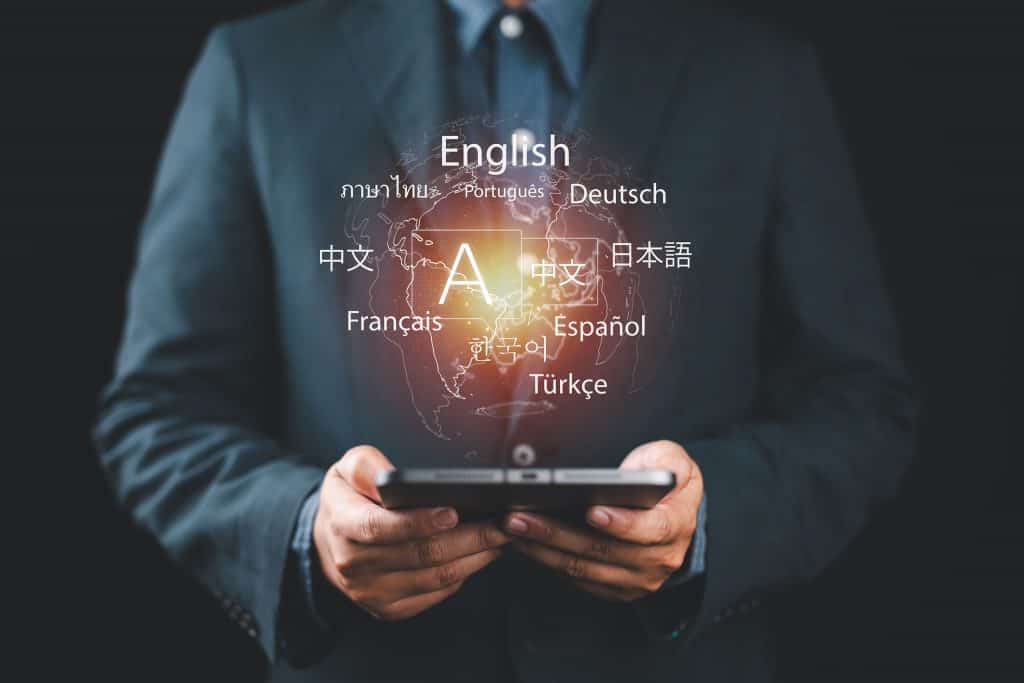 Nomes de idiomas flutuando acima de um tablet nas mãos de um homem