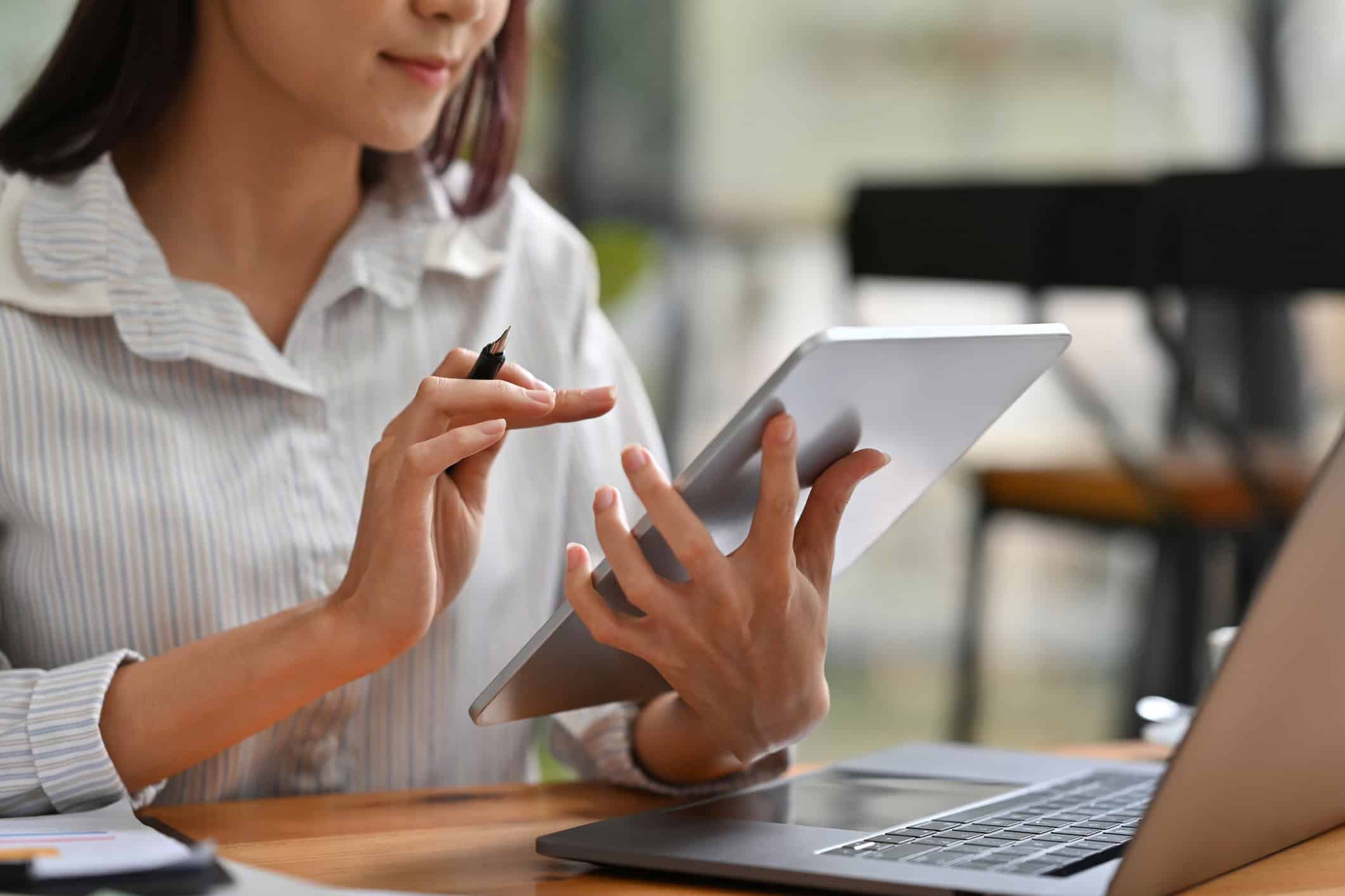 Mulher de negócios em frente ao tablet e notebook