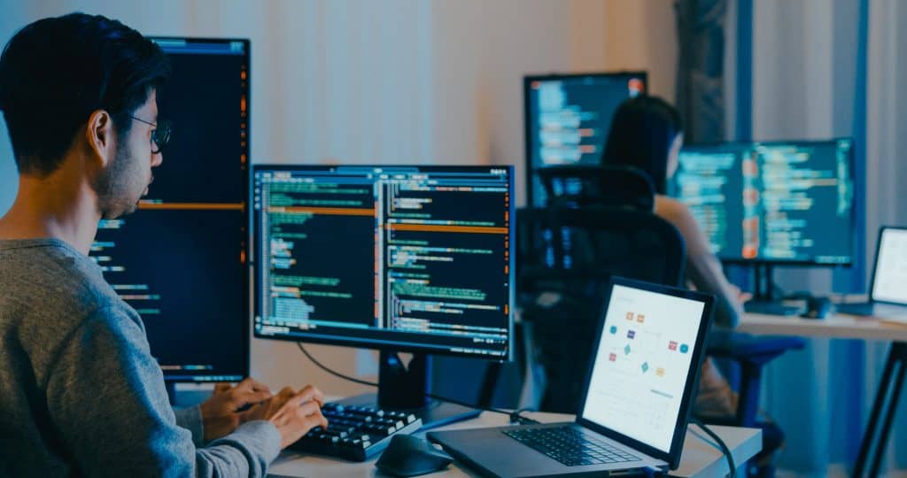 IA no trabalho pode ser indispensável e preocupante, mostram estudos A IA no trabalho já é parte do dia a dia de muitos profissionais, mas principalmente na área da tecnologia. Um levantamento recente conduzido pela divisão de pesquisas DORA, do Google, revelou que 90% dos trabalhadores do setor utilizam algum tipo de ferramenta de IA no trabalho, especialmente para escrever ou revisar códigos de software. O número representa um salto de 14 pontos percentuais em relação ao ano passado, consolidando a tendência de que a tecnologia veio para ficar. Programador em frente a computador