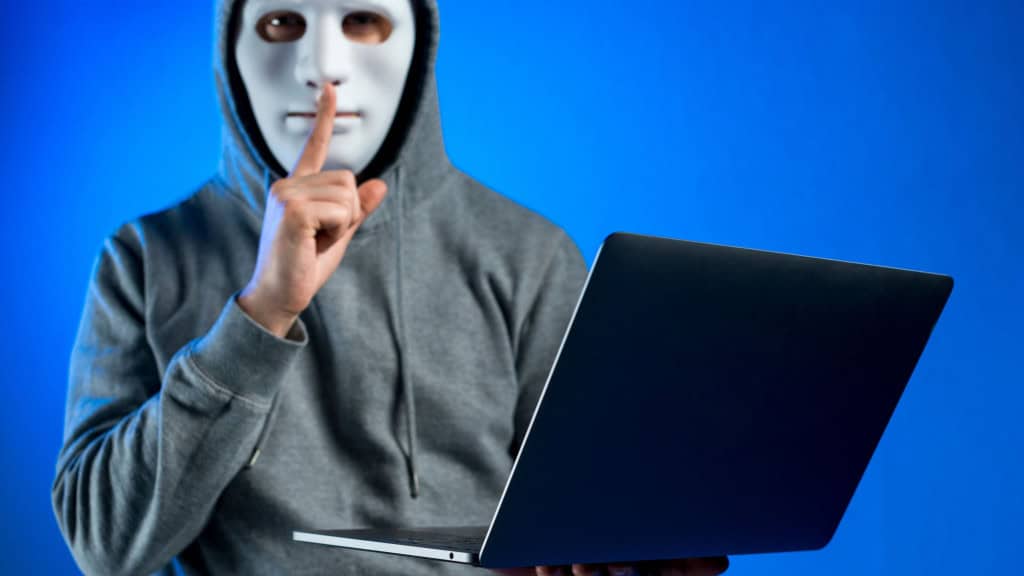 Você comete esses erros? 10 dicas de segurança para jogar online sem riscos Jogar online se tornou parte da rotina de milhões de pessoas no mundo inteiro. No entanto, assim como qualquer outra atividade na internet, jogar online também traz riscos. Roubo de contas, vazamento de dados, golpes e até sequestro de informações são ameaças reais para quem não adota práticas básicas de segurança digital. Homem mascarado segura notebook e faz gesto de silêncio