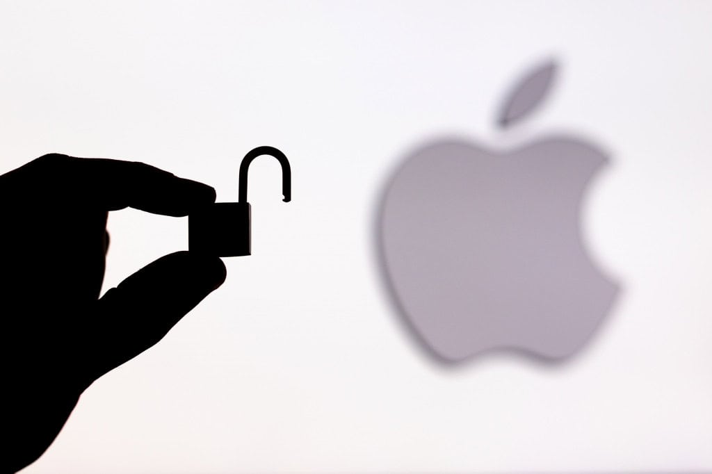 Logo da Apple ao lado da sombra de uma mão segurando um cadeado aberto